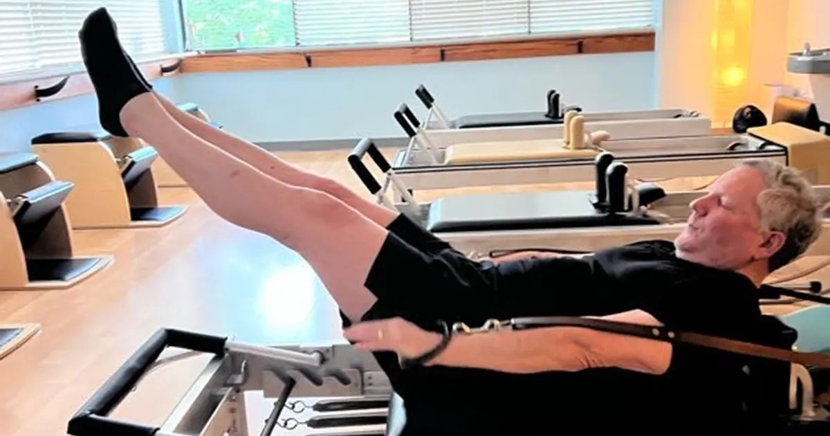 Man performing Coordination exercise on a Pilates reformer at Wilder Pilates in Lenexa, KS