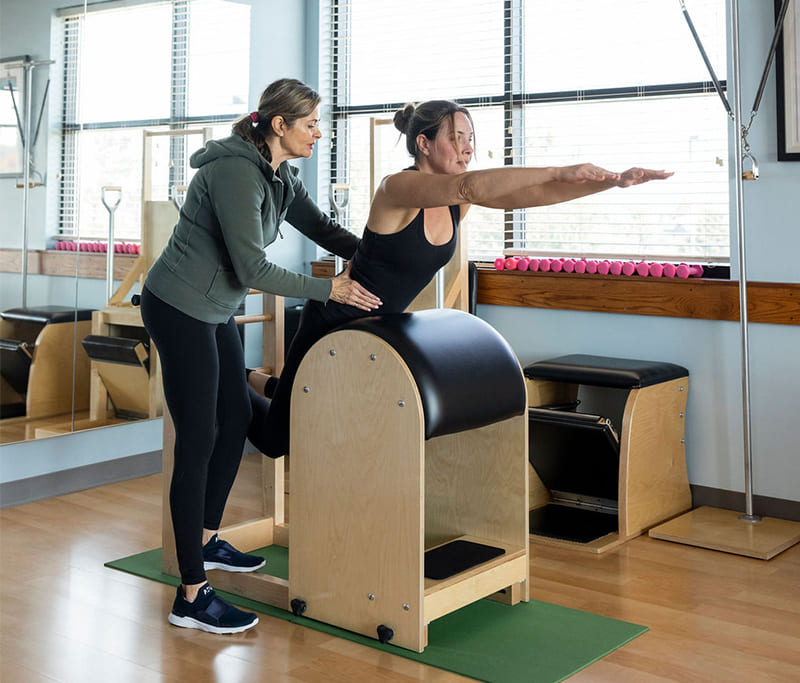 Pilates instructor teaching a private lesson in a classical Pilates studio near Kansas City KS
